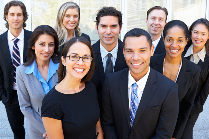 A group of nine business people smile at the camera