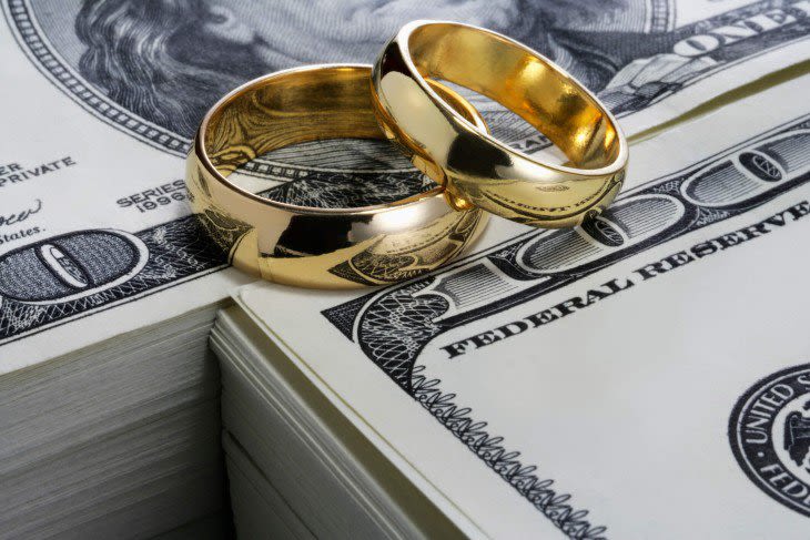Wedding rings on stacks of one hundred dollar bills