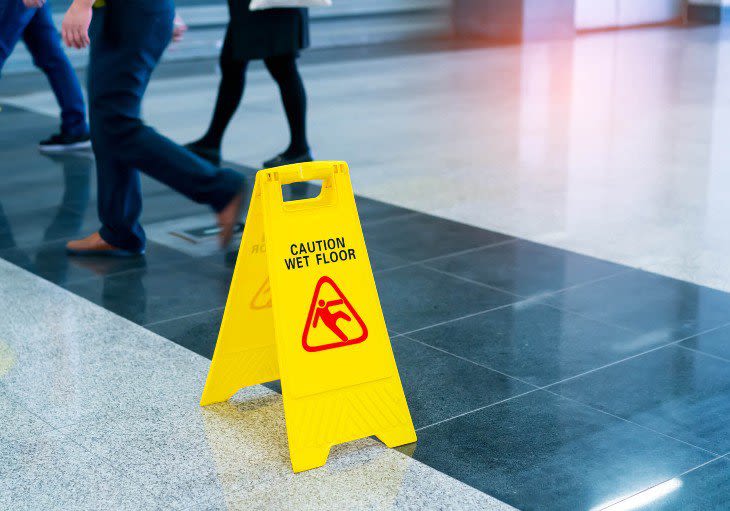 People Walking around a wet floor sign