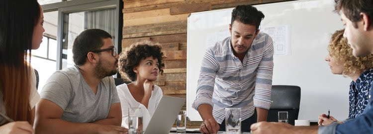 Group of people surround conference table
