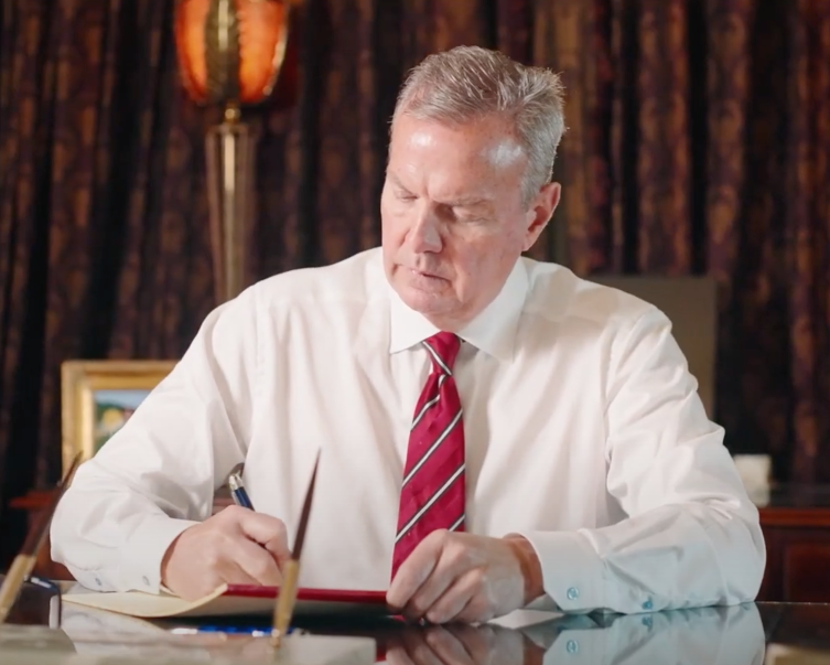 Stephen Rue writing at his desk.