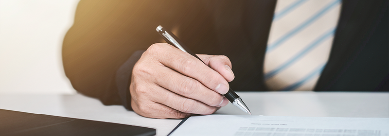 Young business man signing a last will and testament document in the office.