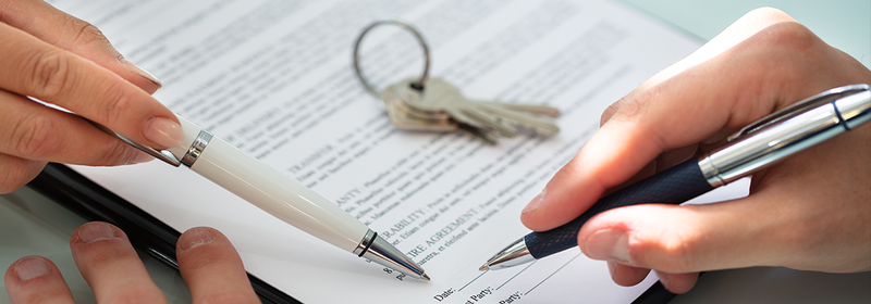 Close-up Of A Person's Hand Filling Contract Form