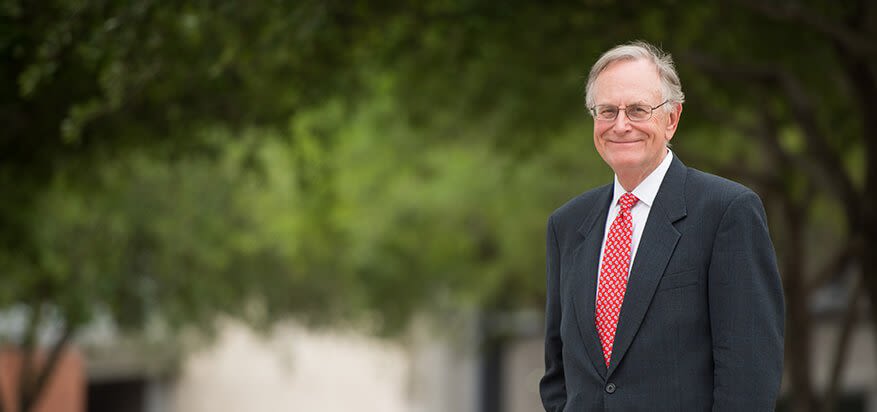 Van Huseman standing in front of office with trees in background