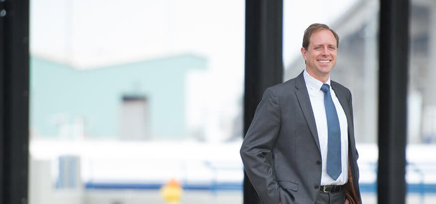 John Swallow standing in front of windows in office building