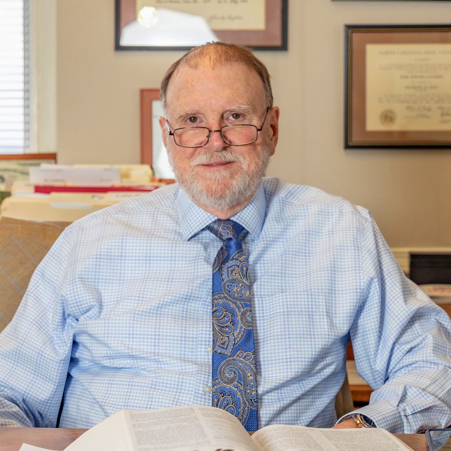 Knudsen at his desk with a book open