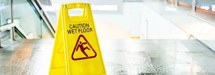 Wet floor sign at the top of a staircase