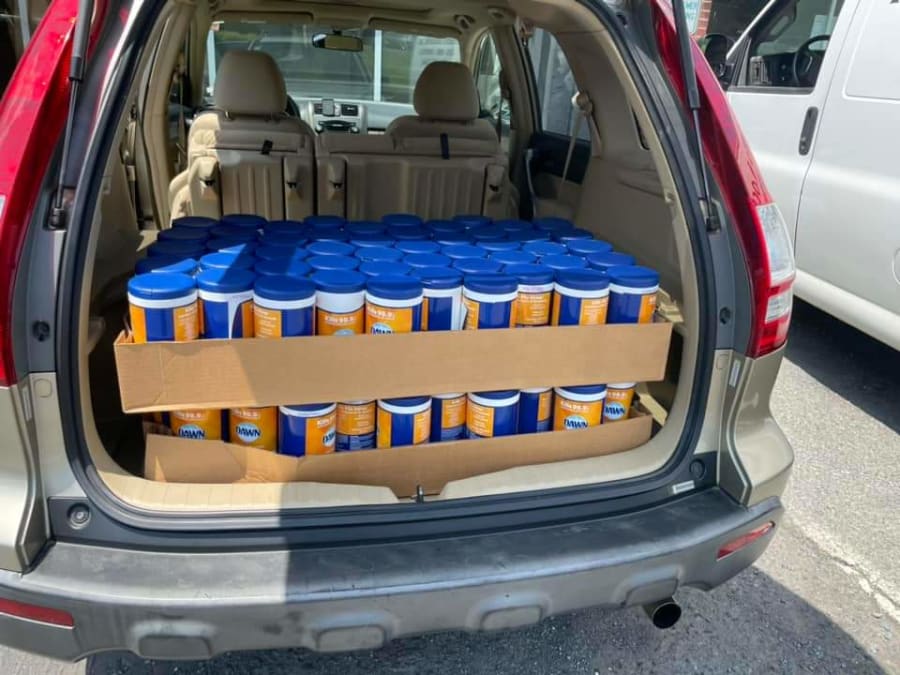 Open SUV trunk packed full of canisters of disinfecting wipes ready for distribution