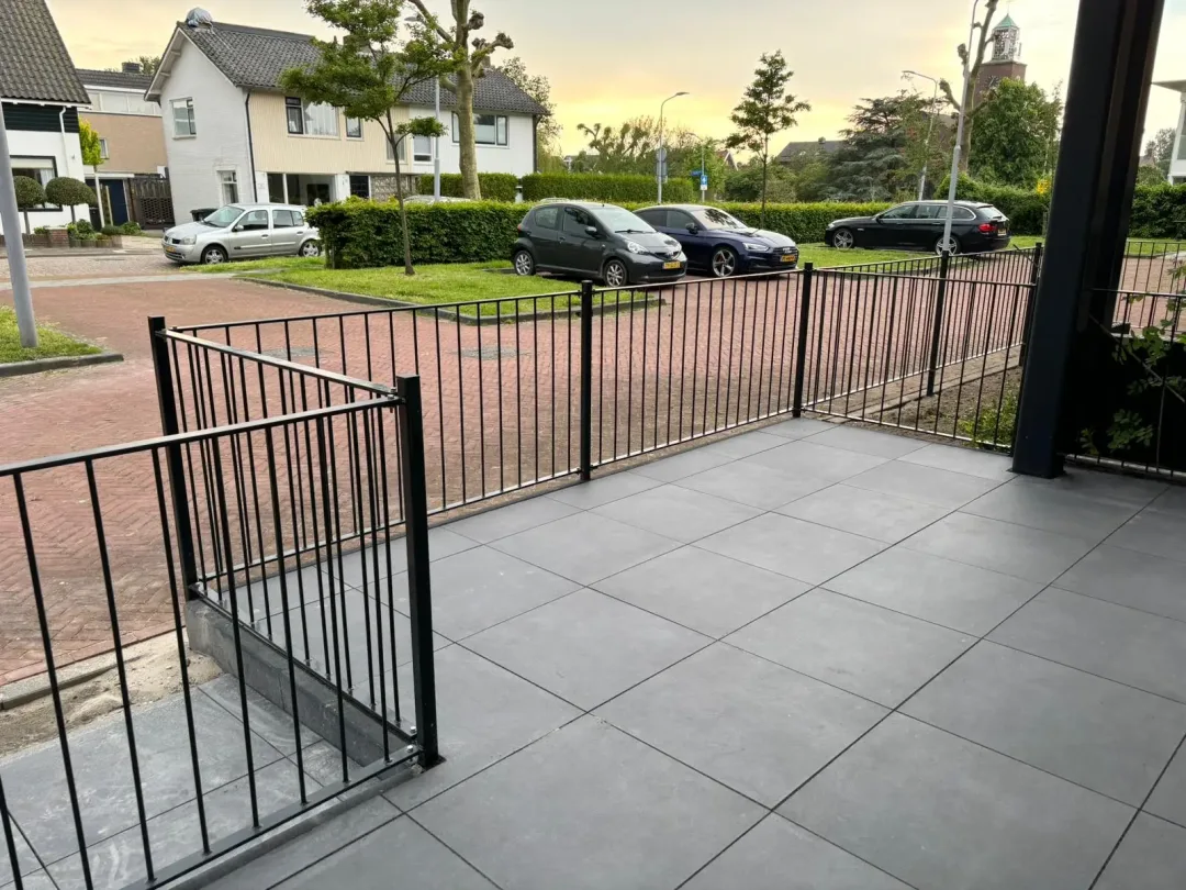 Stalen hekwerk aan een terras voor een huis vanaf het huis