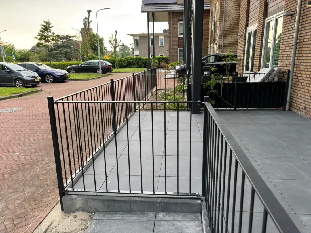Stalen hekwerk aan een terras voor een huis vanaf de zijkant