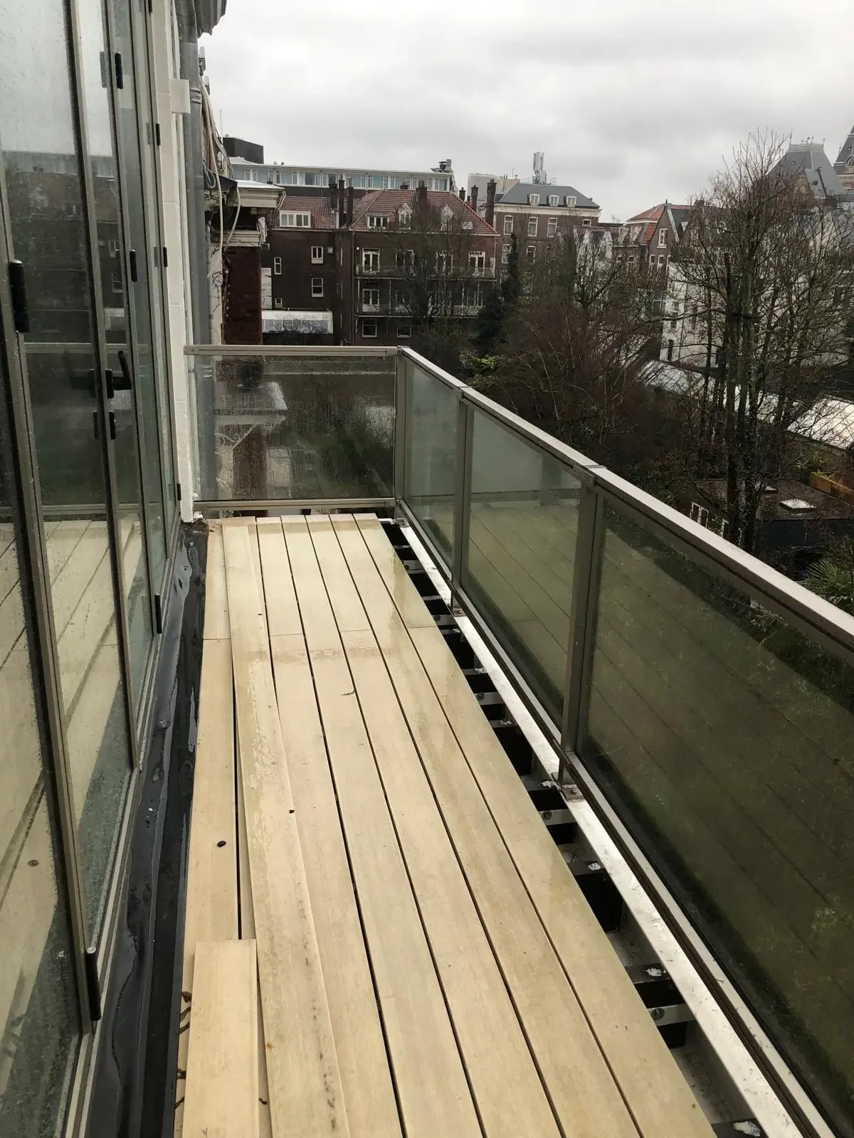 Dit is het aluminium hek ASH-2070 met glas en een donkere RAL kleur vanaf het balkon gezien