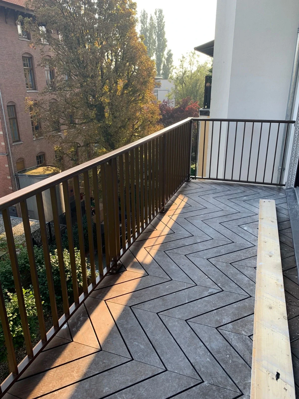 Dit is het aluminium hek ASH-3015 met een donkere RAl kleur op een balkon kijkend naar de muur