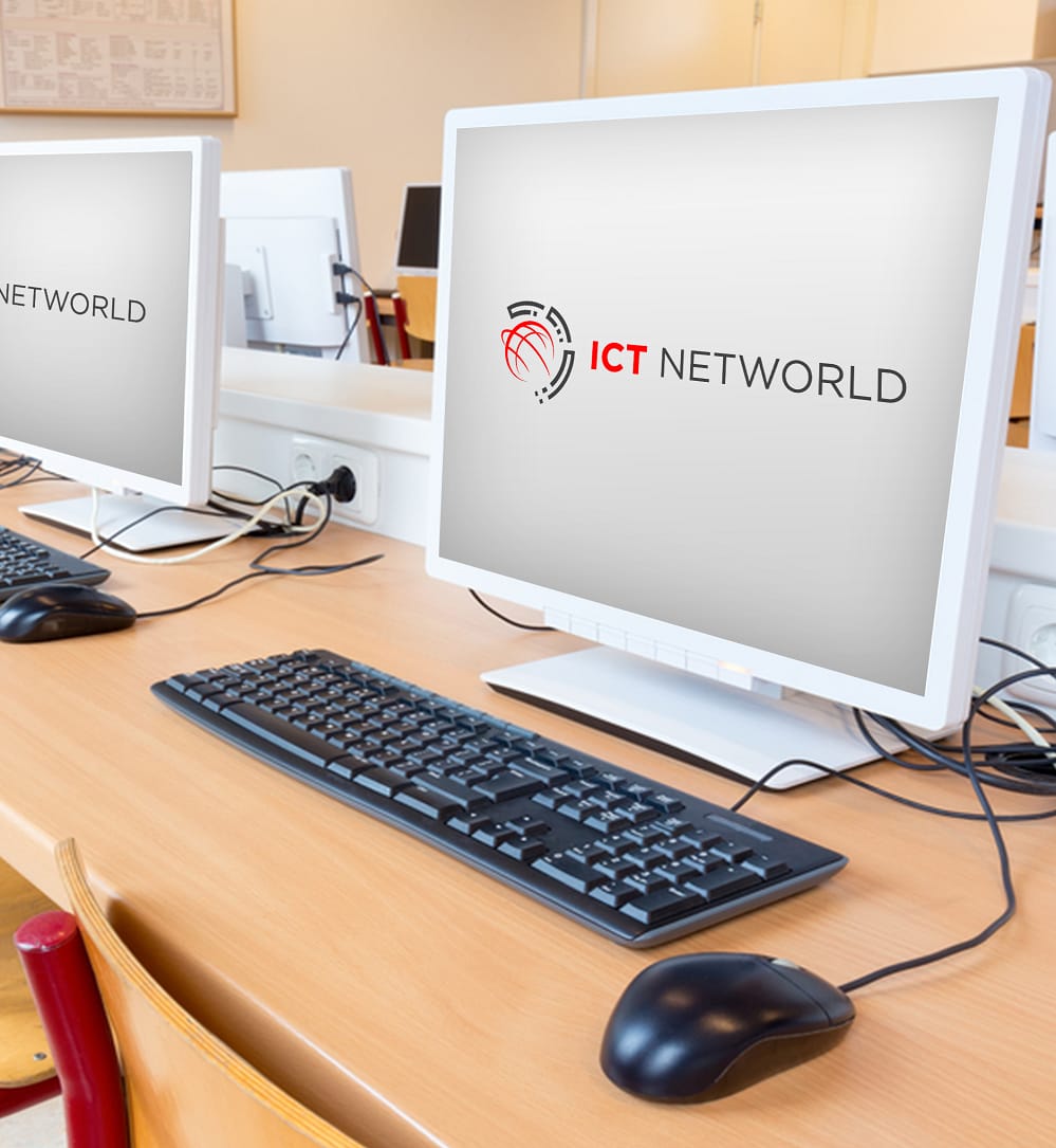 Computers in a classroom with ICT Networld logo on screens