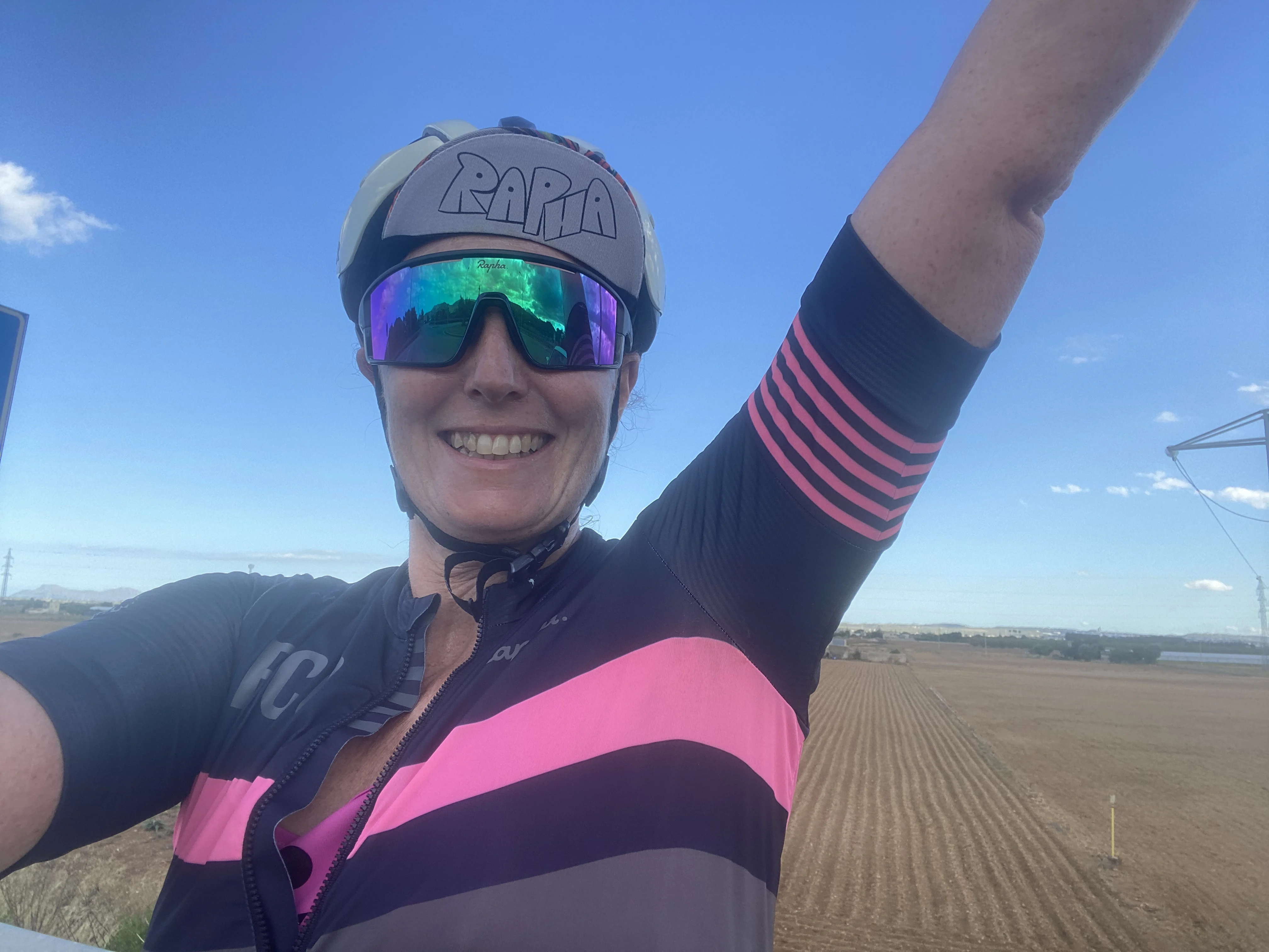 in cycling gear with my hand in the air smiling