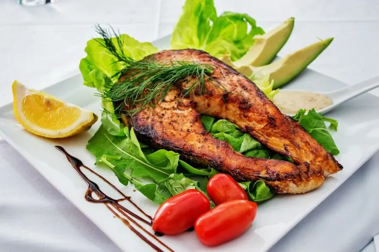 Grilled salmon with vegetables on a white dish
