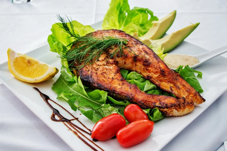 Grilled salmon with vegetables on a white dish
