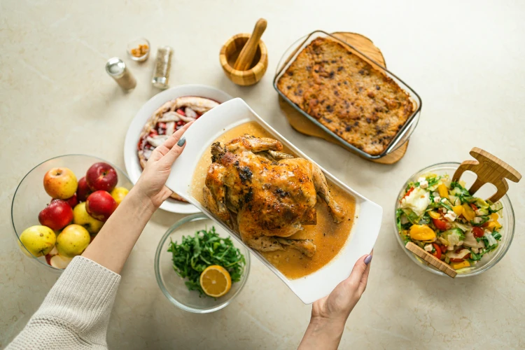 An oven roasted chicken presented next to other dishes
