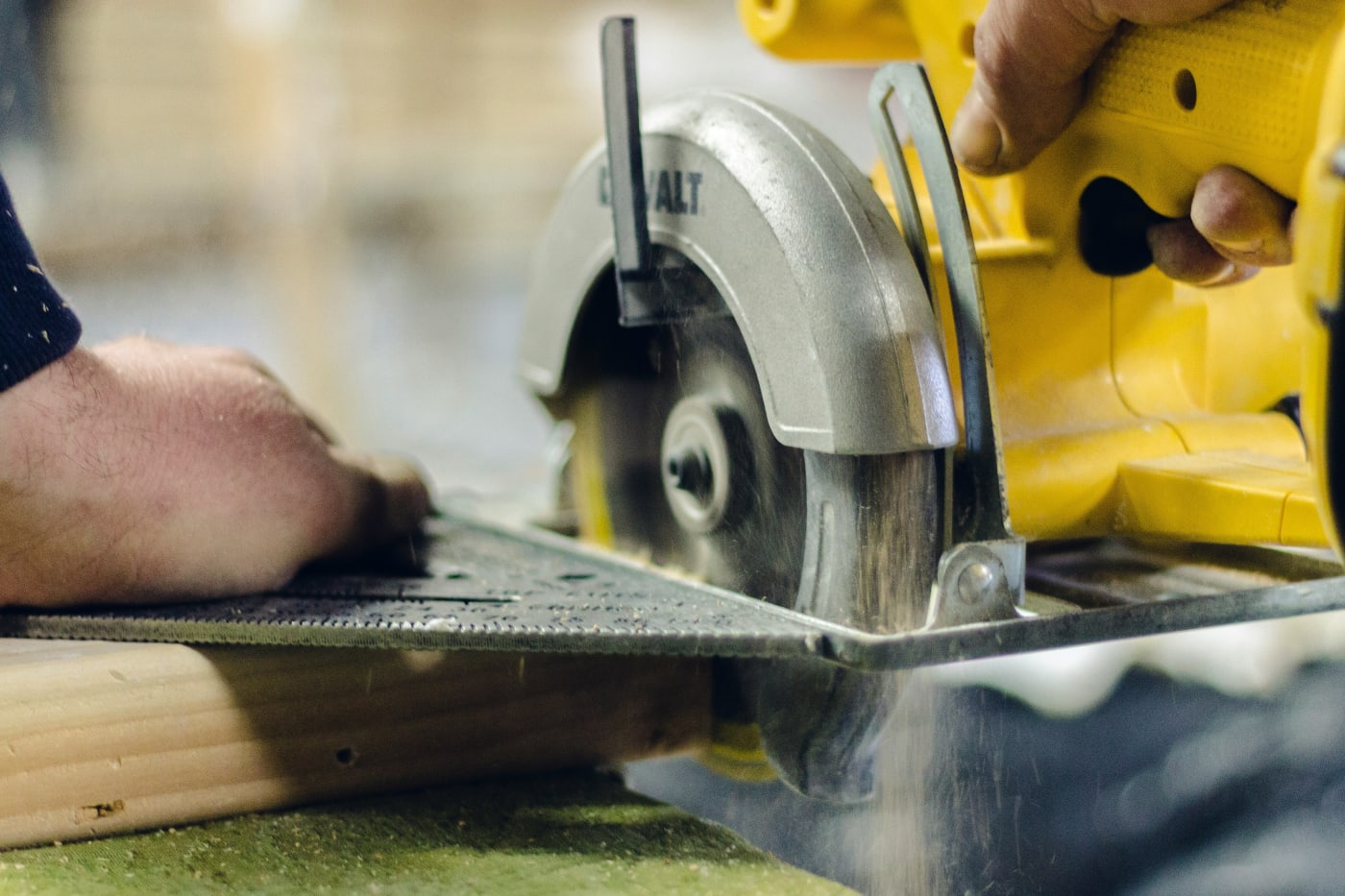 Close-up of a worker using a circular saw to cut wood