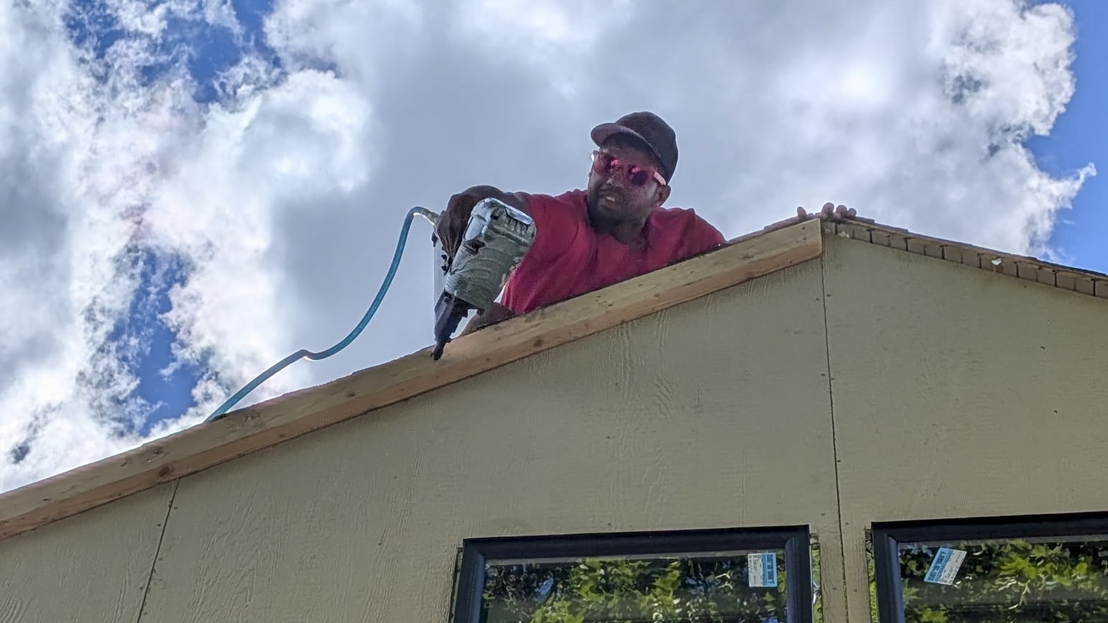 A skilled NIB worker is hard at work on a siding installation project in Spokane, WA. With the bright blue sky as a backdrop, he's using a nail gun to secure the siding, showcasing the level of expertise NIB brings to each job. The image captures the attention to detail that NIB workers put into every exterior project they take on, ensuring quality and precision every step of the way.