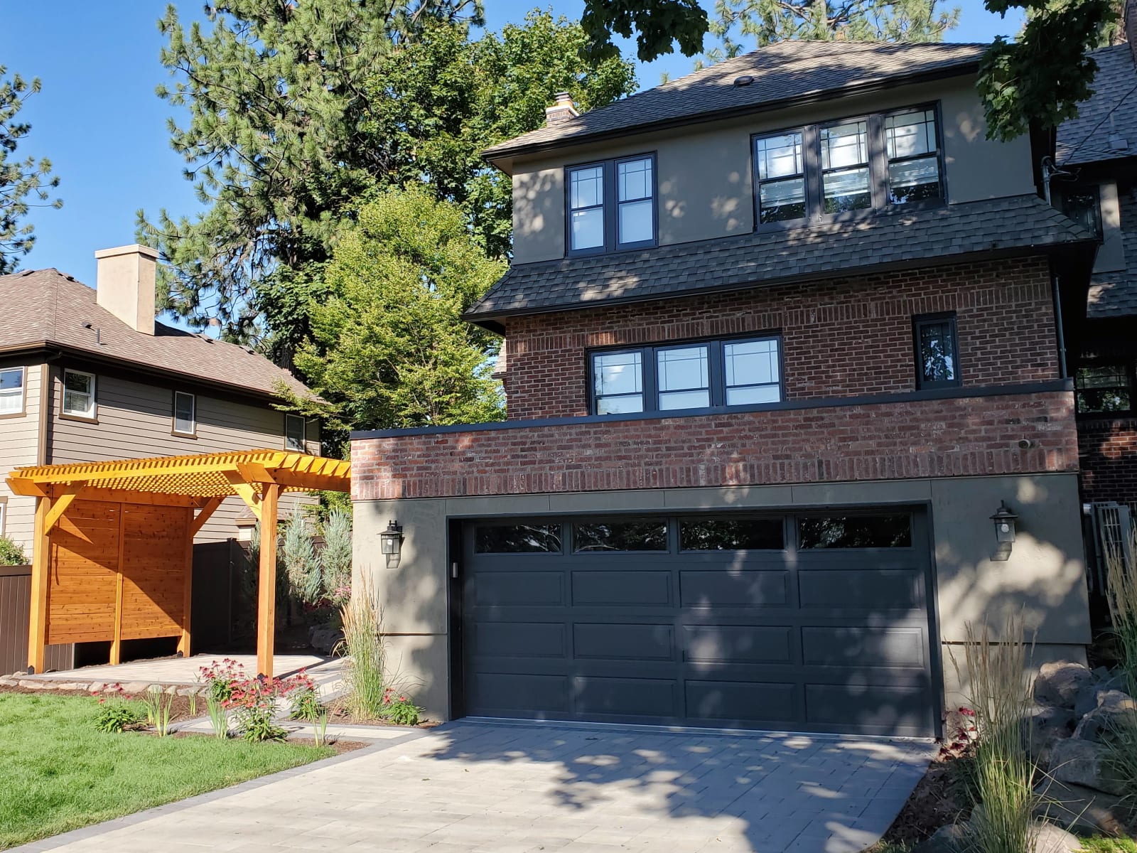 A beautifully completed home exterior remodel in Spokane, WA, exemplifying NIB’s culture of accountability. The photo shows a newly installed garage door and a custom-built pergola, both of which demonstrate NIB's commitment to quality and attention to detail. The neat landscaping and carefully paved walkway enhance the curb appeal, showing how every aspect of the project has been executed with precision. The finished exterior reflects NIB’s high standards, ensuring that every detail is delivered as promised.