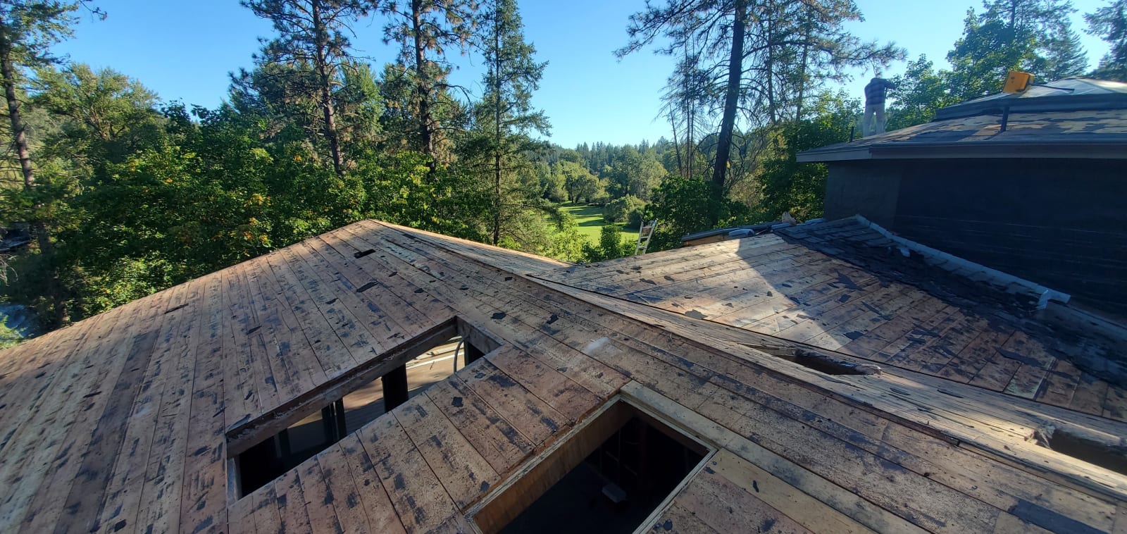 A moment during the roofing phase of a custom home build in Spokane, WA, showcasing NIB’s commitment to precision and quality. With a view of the surrounding landscape, the roof deck is carefully installed, marking a significant milestone in the home's construction process. 