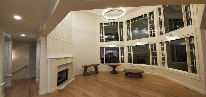 This inviting bedroom features custom paneling on the accent wall installed by NIB in Spokane, WA. The neutral tones of the paint and the luxurious textures of the bedding and pillows create a serene and restful atmosphere. The design, complemented by elegant nightstands and soft lighting, transforms the space into a comfortable retreat, balancing both style and function. The subtle details, like the clean lines of the paneling and the warm wood flooring, provide a perfect backdrop for relaxation.