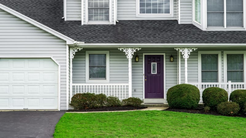 A charming home showcases an excellent siding installation with clean lines and crisp, modern details. The muted grey siding pairs beautifully with the bold purple door, creating a striking contrast that gives the home personality and curb appeal. This project exemplifies how a well-executed exterior remodel can enhance a home’s overall charm.