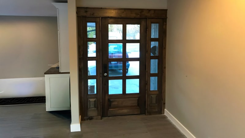 Here we see another beautifully installed wooden door by NIB, enhancing the entryway with natural elegance. This door's traditional grid design brings a rustic charm to the home, with large glass panels that allow plenty of light to fill the space. The solid wood finish and sturdy structure contribute to a classic and welcoming entrance, perfect for Spokane homes looking to blend style with durability. NIB's expert installation ensures that every detail, from the door's framing to the glass panels, is done to perfection.