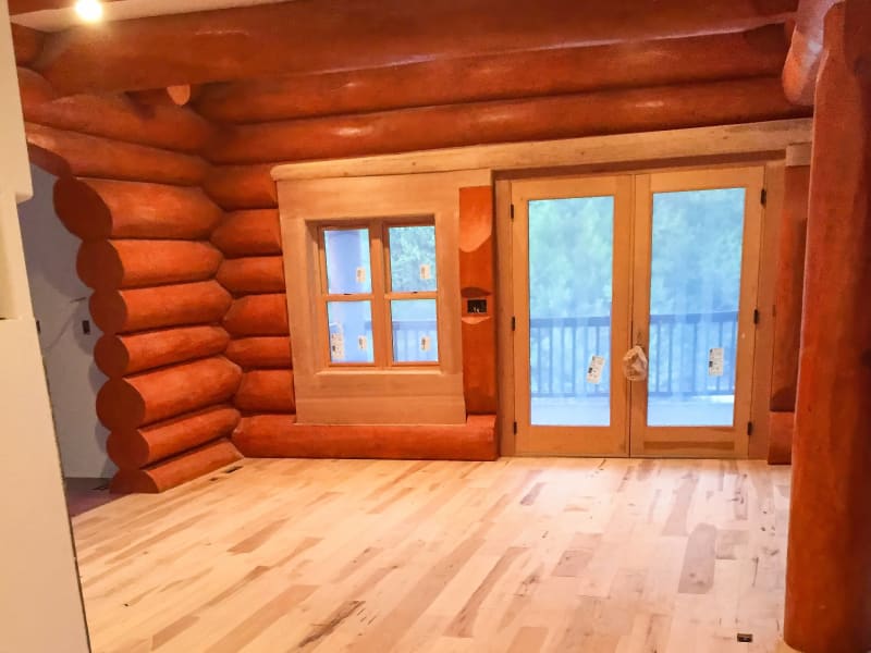 This inviting log cabin space is enhanced with NIB’s custom window and door installation, based in Spokane, WA. The beautiful double doors, with their natural wood finish, complement the warmth and texture of the log walls. The large windows allow natural light to flood the room, creating an open and airy feeling. NIB’s attention to detail and craftsmanship ensures that every element fits perfectly with the rustic charm of the cabin, making it a welcoming retreat.