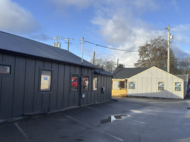 A view of a recent siding installation completed by NIB in Spokane, WA. On the left, you can see the building with freshly installed dark-colored siding, creating a modern and sleek look. 