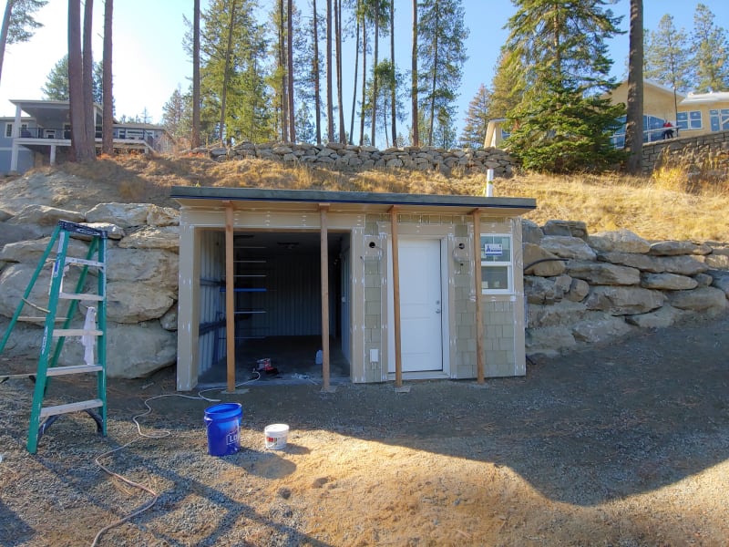 A newly built small structure with its walls being painted and the door installed. The project site, located in Spokane, WA, is being worked on by NIB, showcasing the company's ability to complete home addition projects in various stages.