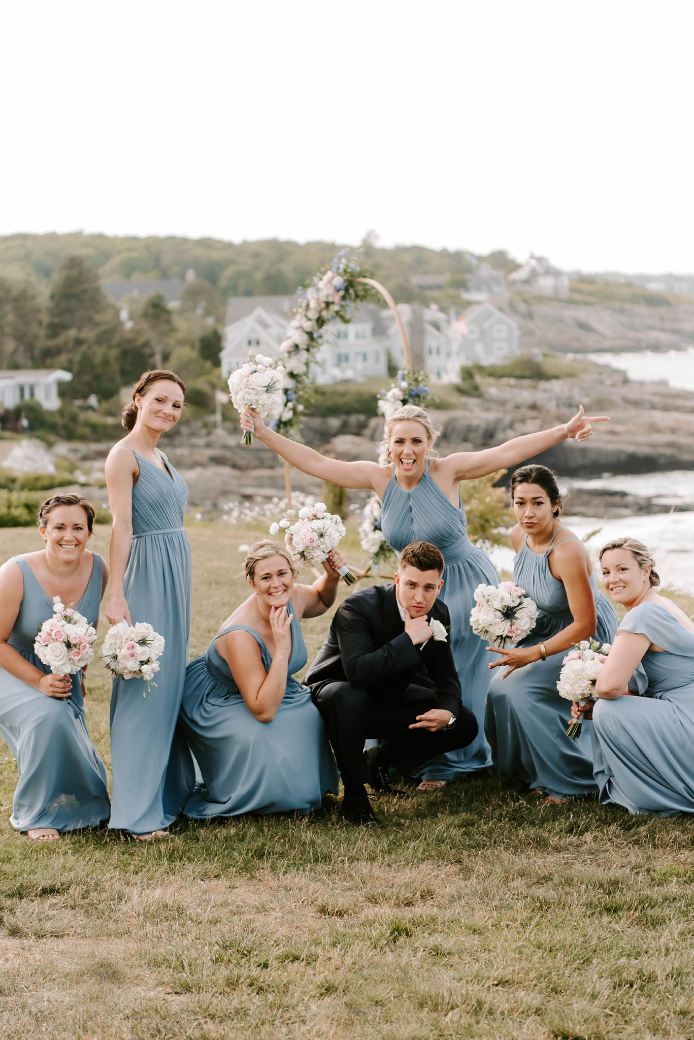 Wedding party with light blue bridesmaid dresses and white blush bouquets by Designs By Don Florist.