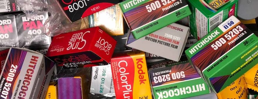 Rolls and boxes of various film stocks including Kodak Portra, Fujifilm, and Ilford arranged in a flat lay