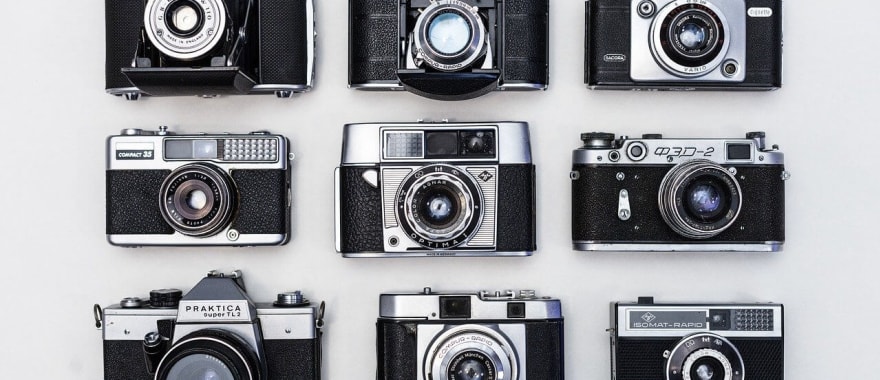 Photographer shooting with a 35mm film camera on the street in golden hour light