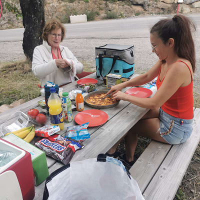 Deux personnes faisant un ravitaillement avec beaucoup de nourriture sur table de pique niqe