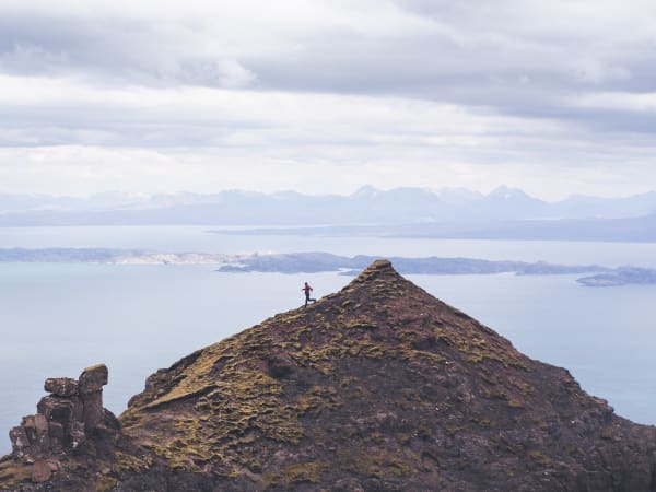 Coureur sur une crête de montagne au dessus d'une mer de nuage pratiquant le trail running