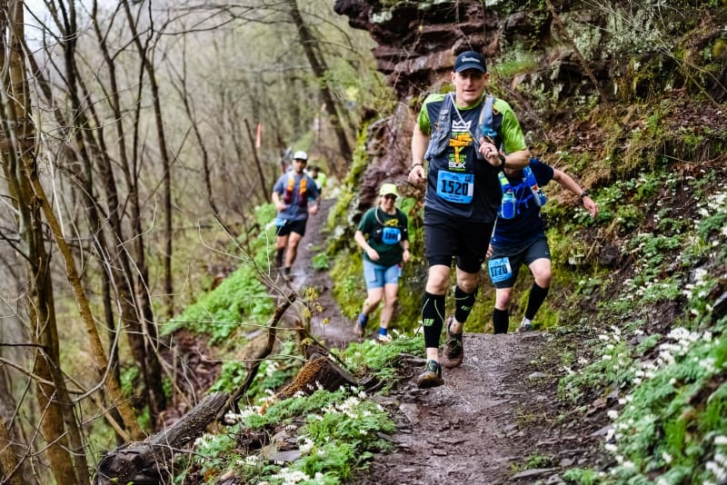 Groupe de coureur de trail pendant une compétition de trail sur un petit chemin en forêt