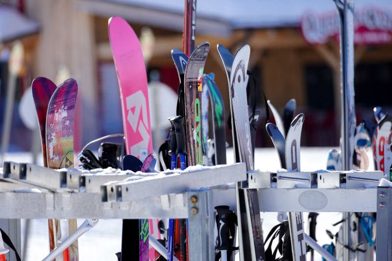 Vue des plusieurs ski et snowboard posé sur un rangement de ski et de snowboard