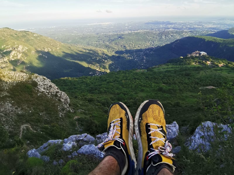 VUe des jmabes et d'une paire de chaussures de trail dans les Alpes Maritimes au sommet de Gourdon