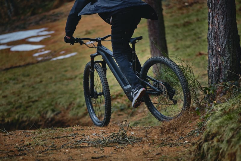 Personne faisant du VTT électrique en forêt