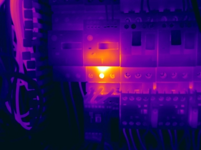 Thermal image showing localised internal heating within a motor overload unit, indicating possible degradation and nuisance-tripping risk