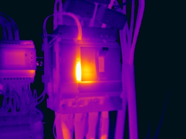 Thermal image showing excessive localised temperature at an MCCB shunt-trip or undervoltage coil, indicating possible degradation