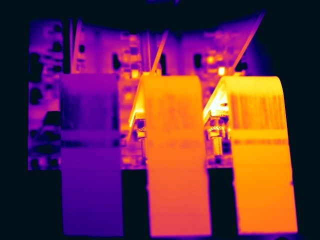Thermal image showing temperature rise at an LV switch-to-busbar assembly under comparable phase loading, indicating possible high resistance or internal switch degradation