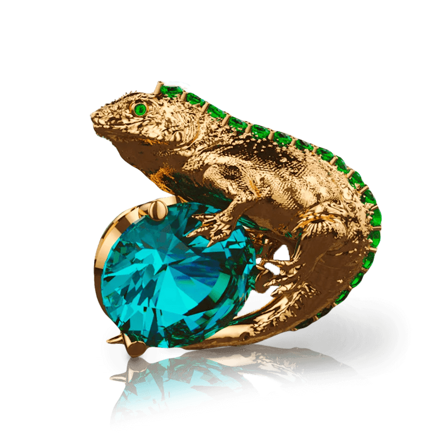 Representando la fauna de Galápagos, esta representación de iguana en oro 18k sostiene un zafiro central. Detalles de esmeraldas embellecen esta joya de lujo única