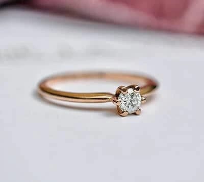 Una elegancia centelleante se revela en nuestra sortija, donde el oro amarillo realzan la belleza del diamante central