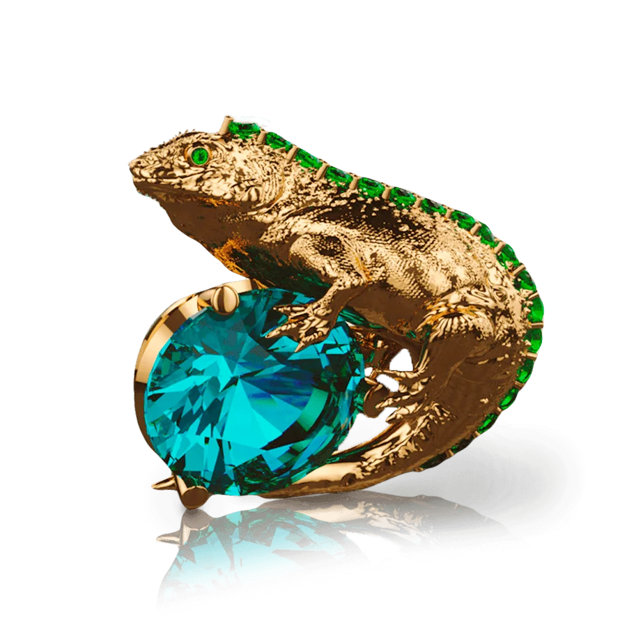 Representando la fauna de Galápagos, esta representación de iguana en oro 18k sostiene un zafiro central. Detalles de esmeraldas embellecen esta joya de lujo única