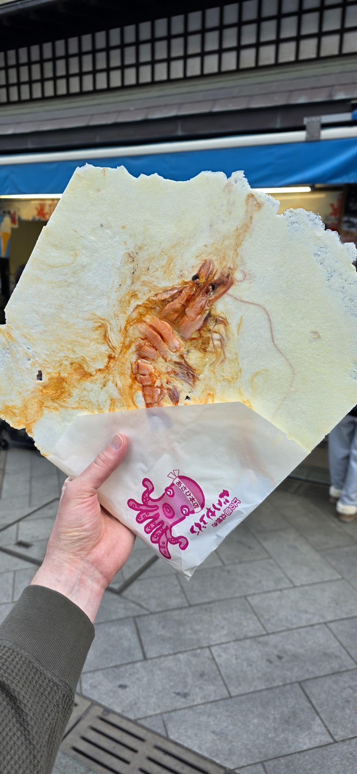 A giant prawn senbei being pressed flat on a hot iron at Asahi Honten
