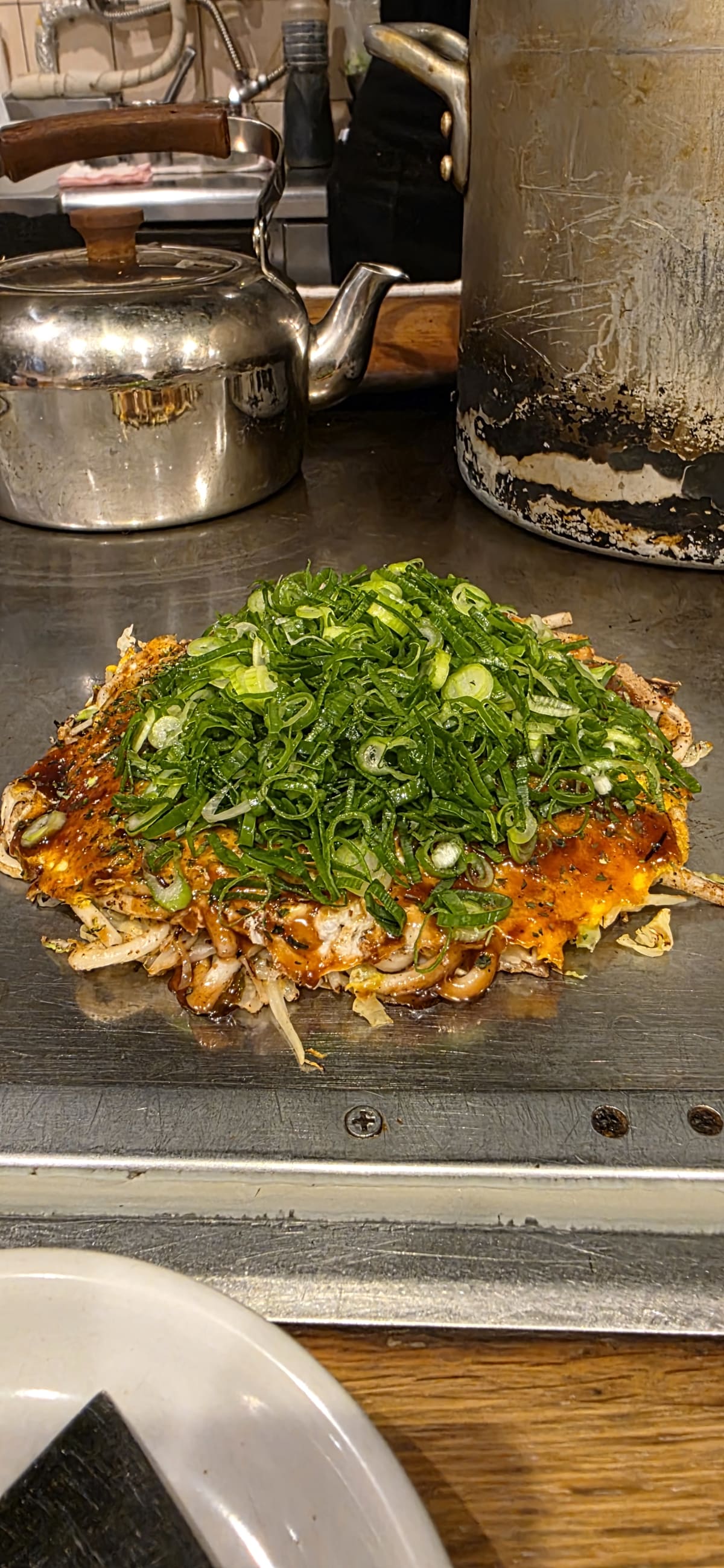 An okonomiyaki savoury pancake with bonito flakes and mayonnaise