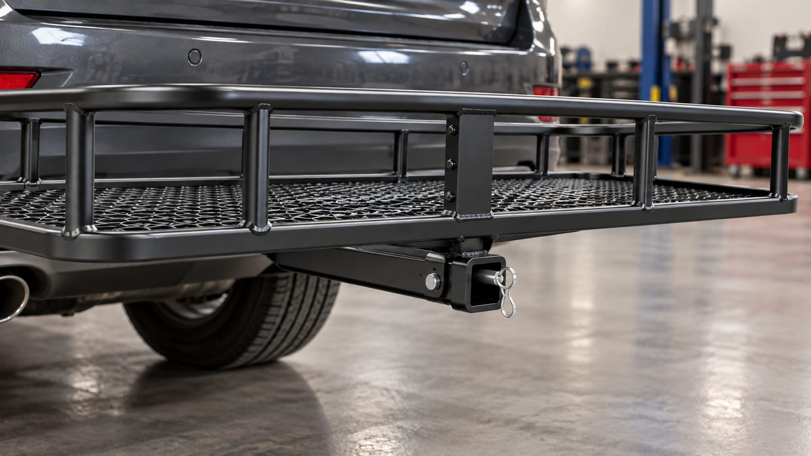 Close-up of a black hitch cargo carrier receiver shank, locking pin, center support and mesh platform