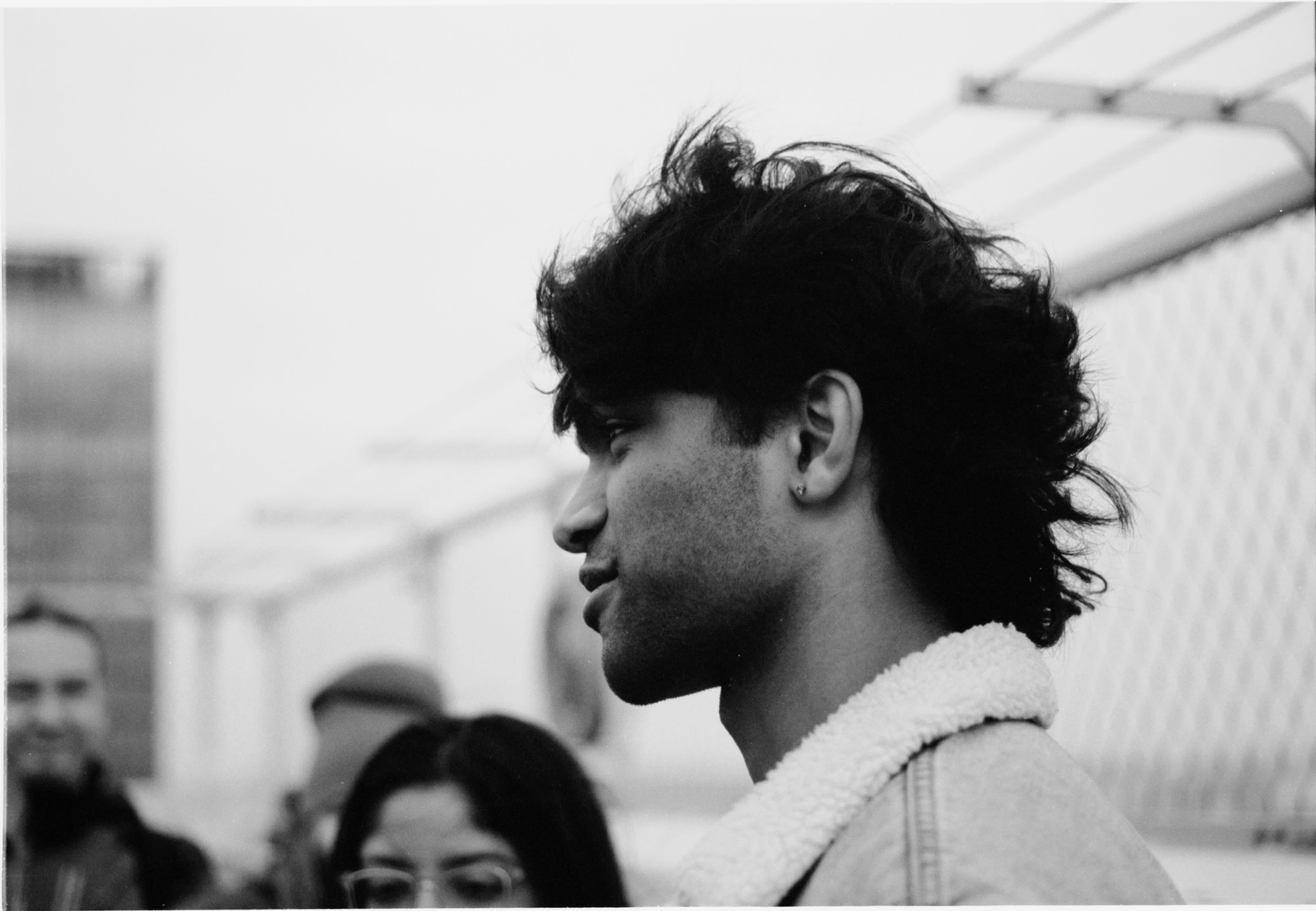 A friend with curly hair in a shearling jacket, in profile